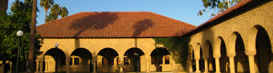 Image of the porticoed Main Quad in the morning with palm tree shadows