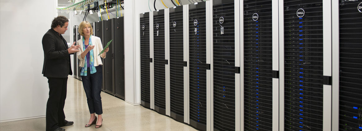 man and woman standing in front of a large bank of computer servers